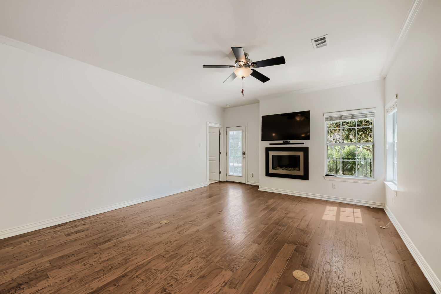 6715 Windrift Way, Unit 28 Austin, TX 78745 - Photo 8 of 19 Hardwood floors and a sleek fireplace create a warm and inviting atmosphere in this generous living space.