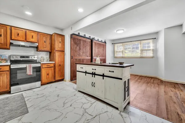 a kitchen with stainless steel appliances granite countertop a stove a sink and a refrigerator