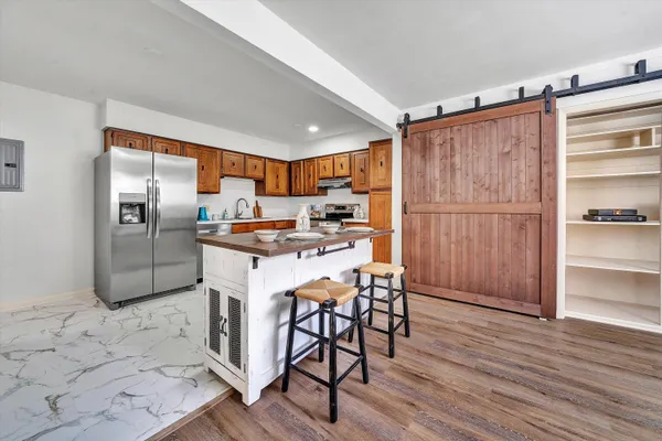 a kitchen with granite countertop stainless steel appliances a refrigerator and counter space
