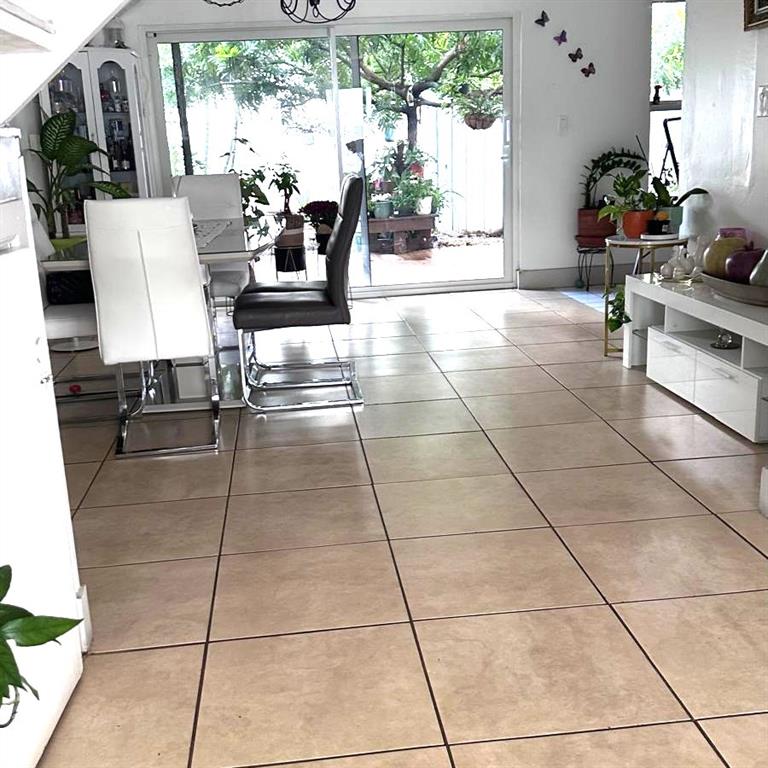 6728 Southwest 40th Street, Unit 6728 Fort Lauderdale, FL 33314 - Photo 8 of 13 a living room with couches a flat screen tv and a dining table with garden view