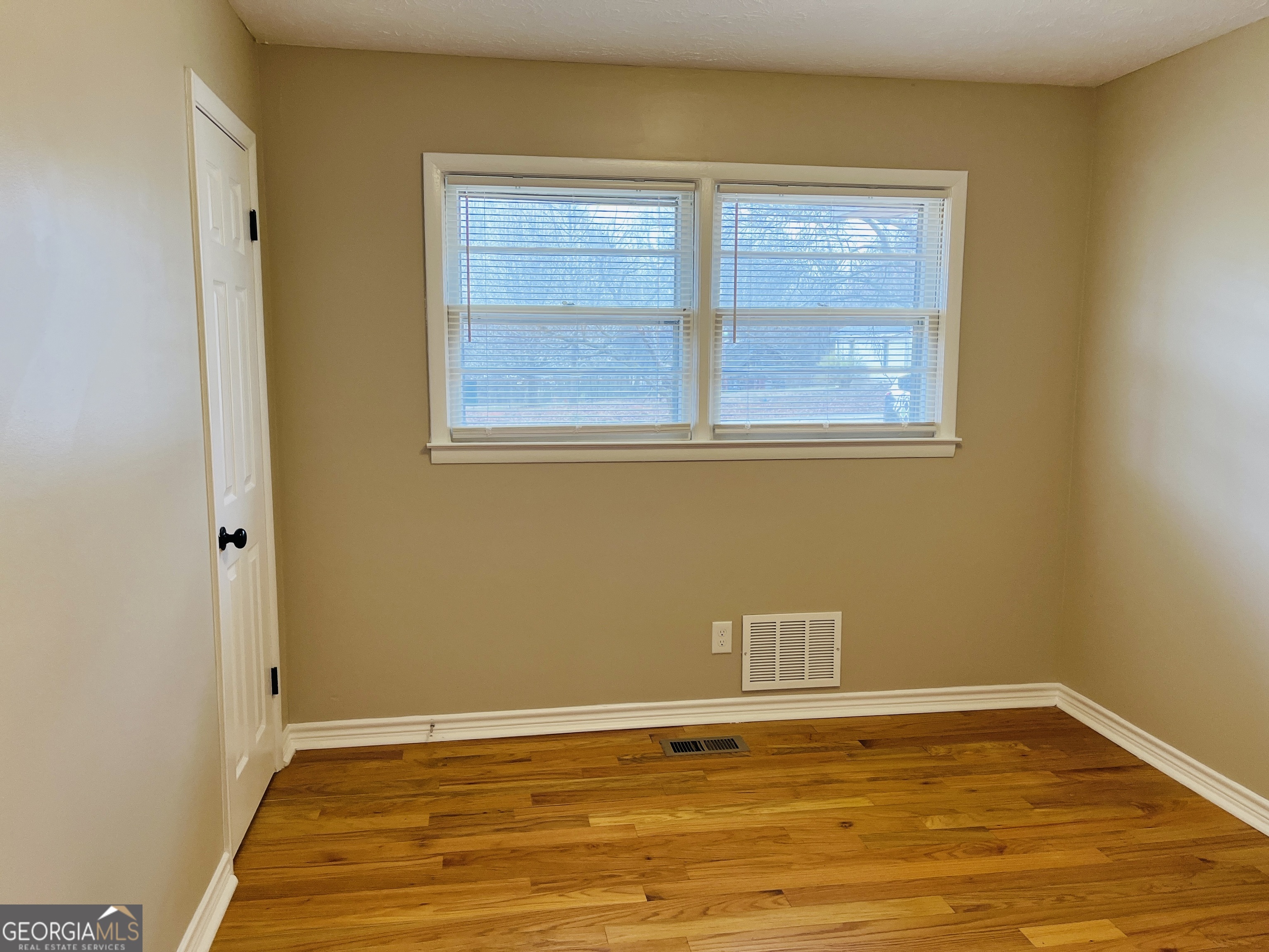 1085 Horsley Mill Road Carrollton, GA 30116 - Photo 14 of 26 a view of an empty room with wooden floor and a window