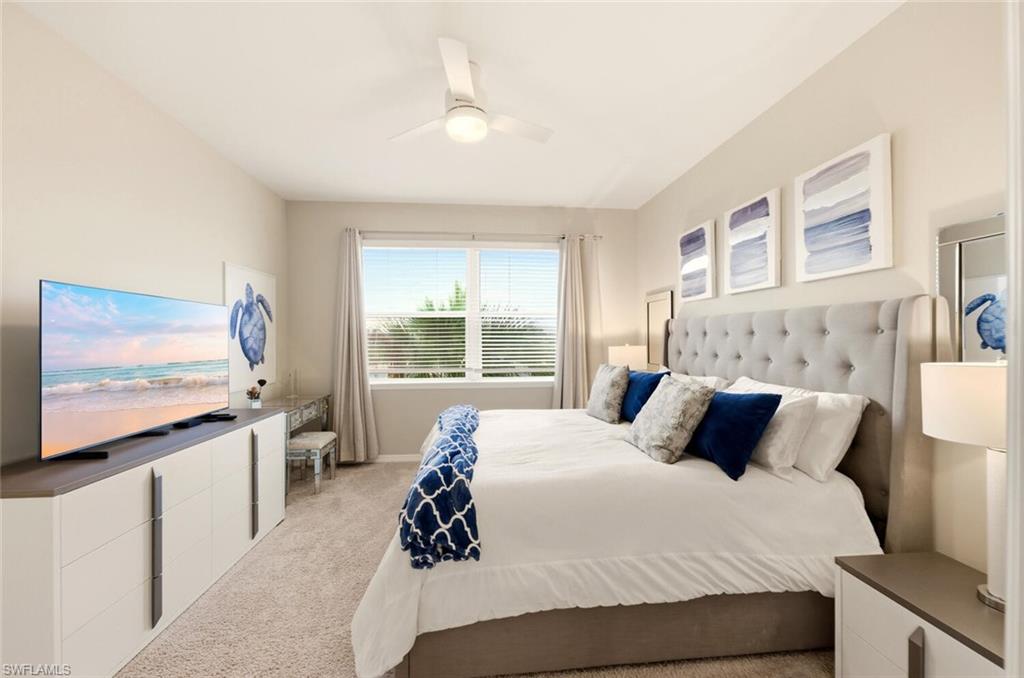 9365 Pocida Court, Unit 202 Naples, FL 34119 - Photo 19 of 40 a bedroom with a bed and a flat screen tv