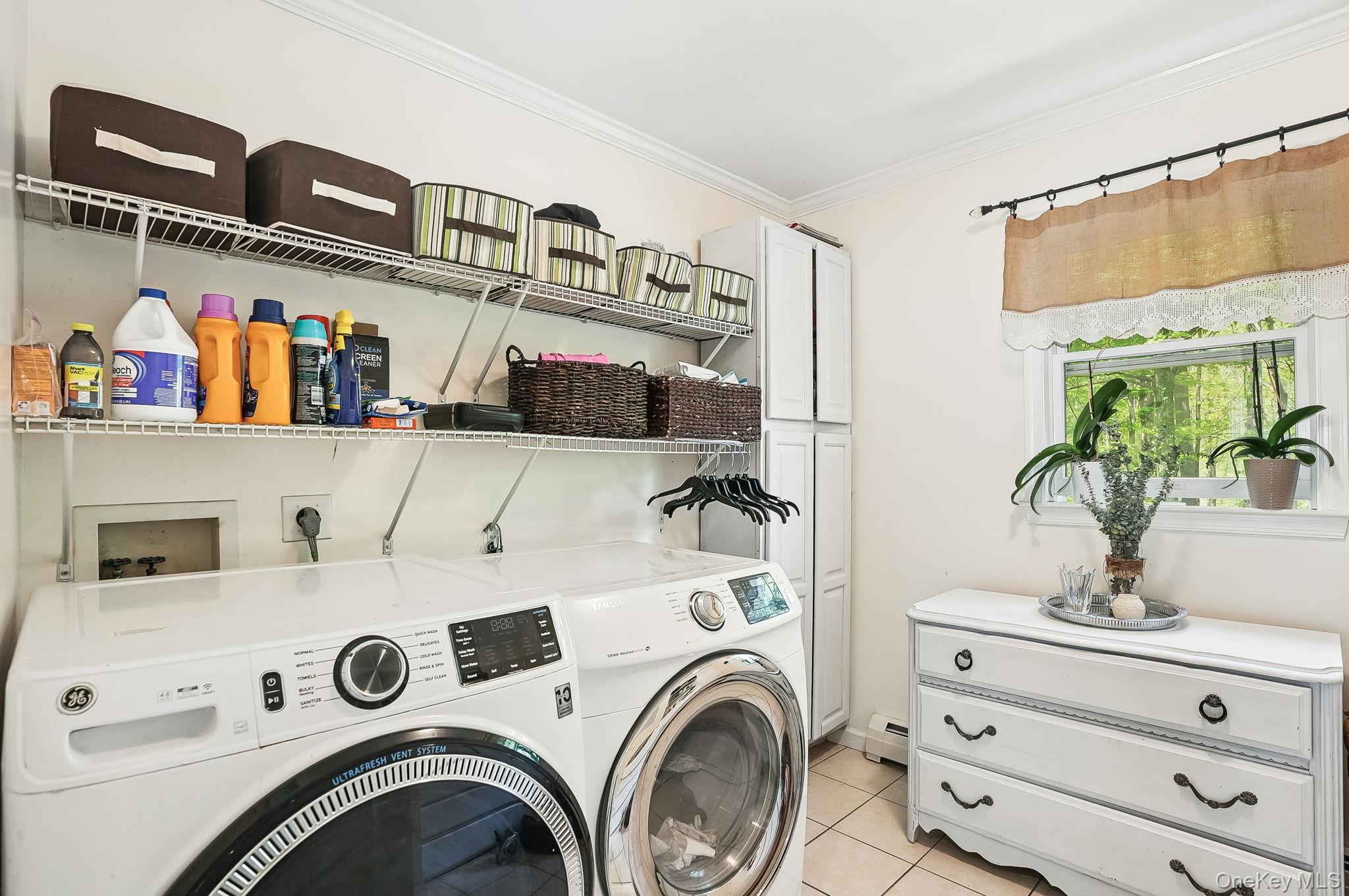 304 Church Road Putnam Valley, NY 10579 - Photo 13 of 50 Laundry room featuring separate washer and dryer, ornamental molding, light tile patterned flooring, cabinet space, and a baseboard heating unit