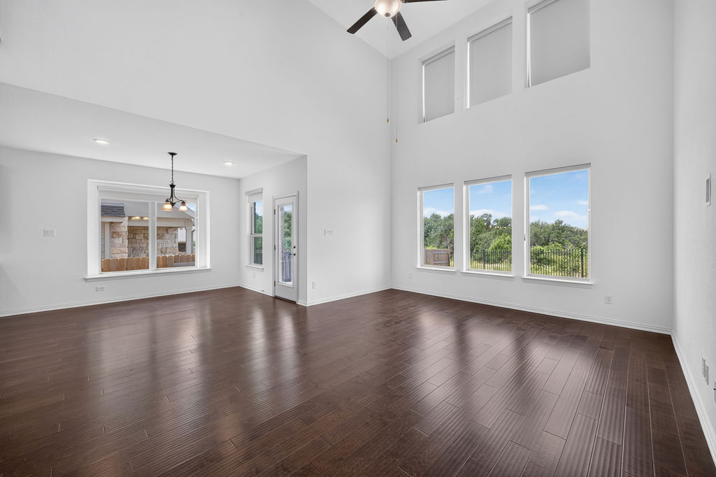 1332 Ridge Runner Drive Georgetown, TX 78628 - Photo 7 of 40 A spacious living area with soaring ceilings and gleaming hardwood floors invites relaxation and natural light.