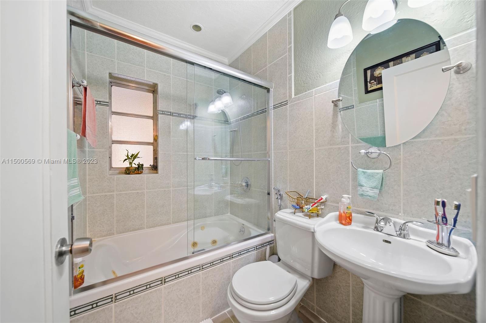 1828 Southwest 6th Street Miami, FL 33135 - Photo 12 of 50 a bathroom with a bathtub shower sink mirror vanity and toilet