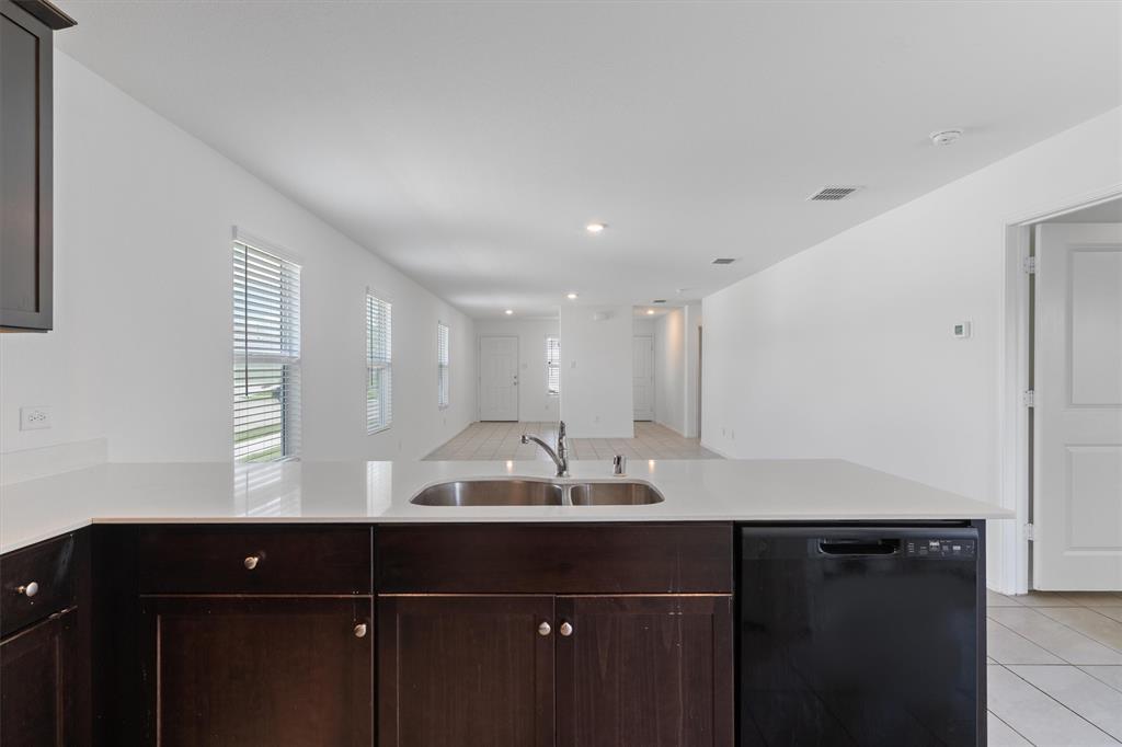 7781 Ruellia Road McKinney, TX 75071 - Photo 10 of 25 Kitchen featuring dishwasher, light tile patterned floors, light countertops, dark brown cabinetry, and recessed lighting