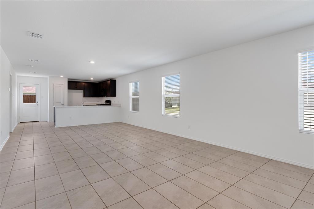 7781 Ruellia Road McKinney, TX 75071 - Photo 5 of 25 Unfurnished living room featuring light tile patterned flooring, plenty of natural light, and recessed lighting