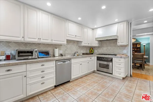 a kitchen with granite countertop white cabinets and appliances