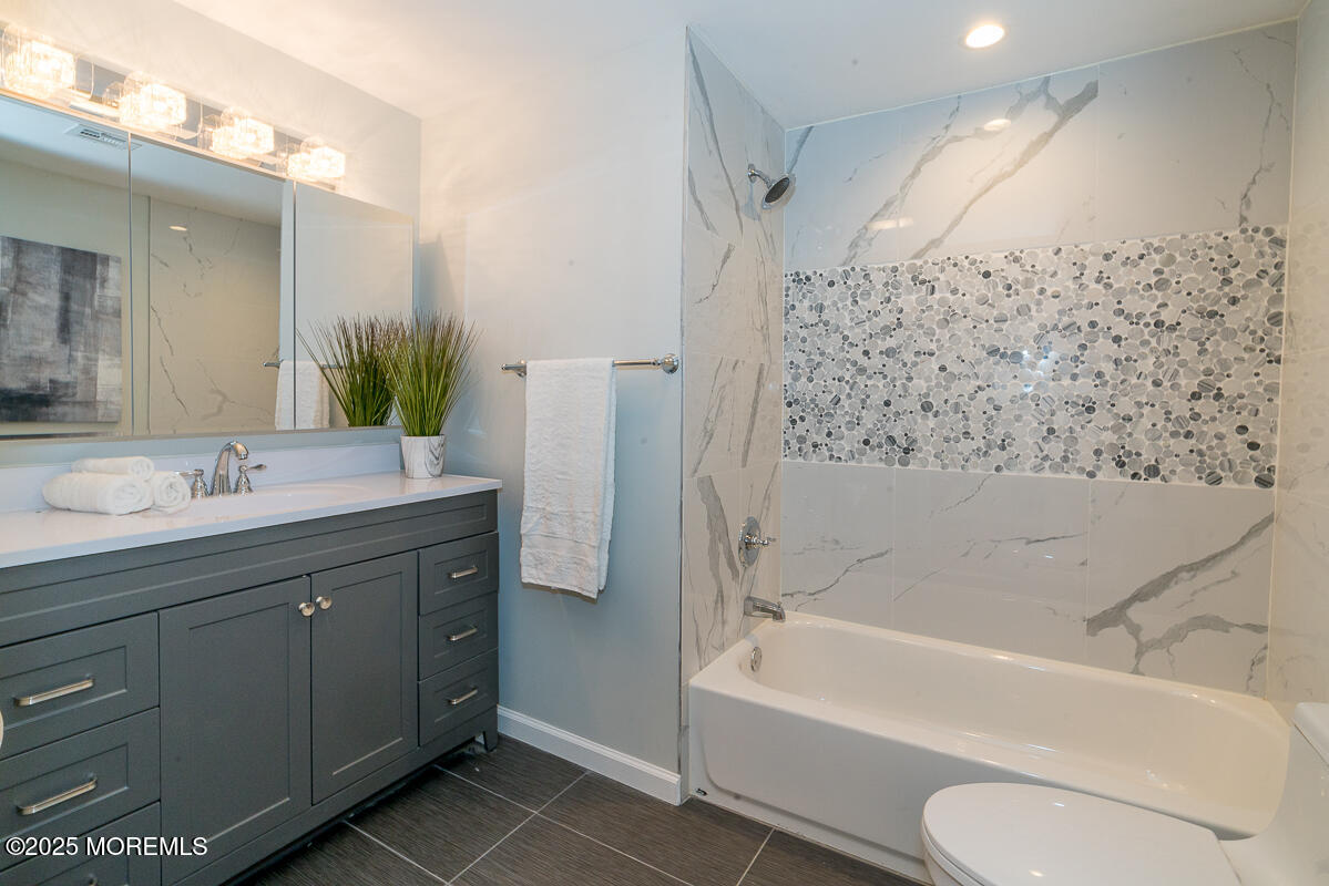 21 Wickatunk Road Manalapan, NJ 07726 - Photo 16 of 48 a bathroom with a bathtub toilet sink vanity and mirror