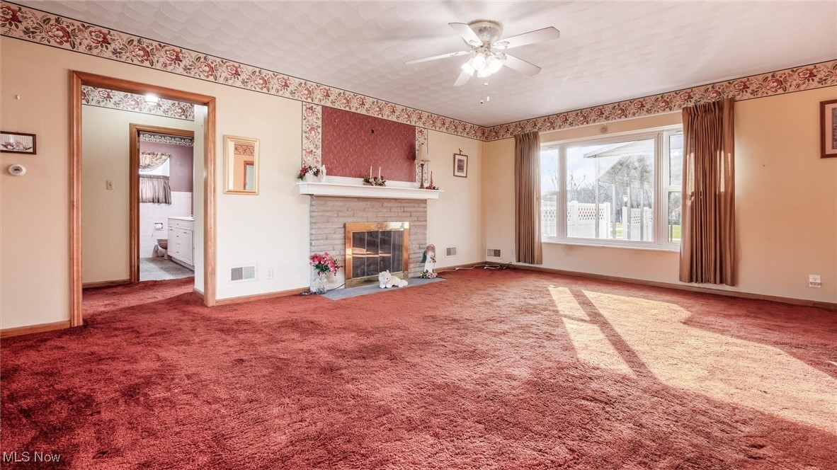 1950 Newark Road Zanesville, OH 43701 - Photo 13 of 39 Unfurnished living room featuring carpet, ceiling fan, and a fireplace