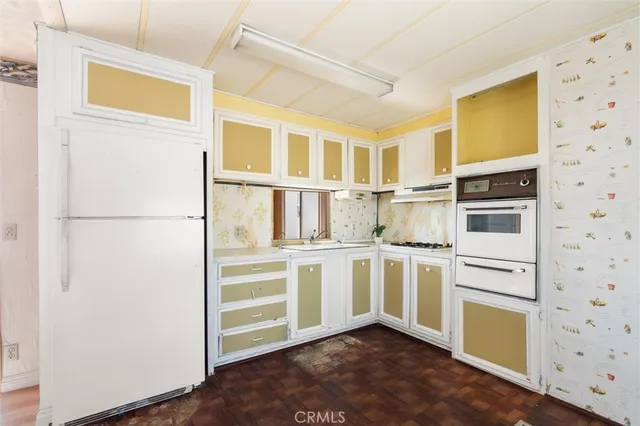 a kitchen with stainless steel appliances granite countertop a sink and a stove with white countertops