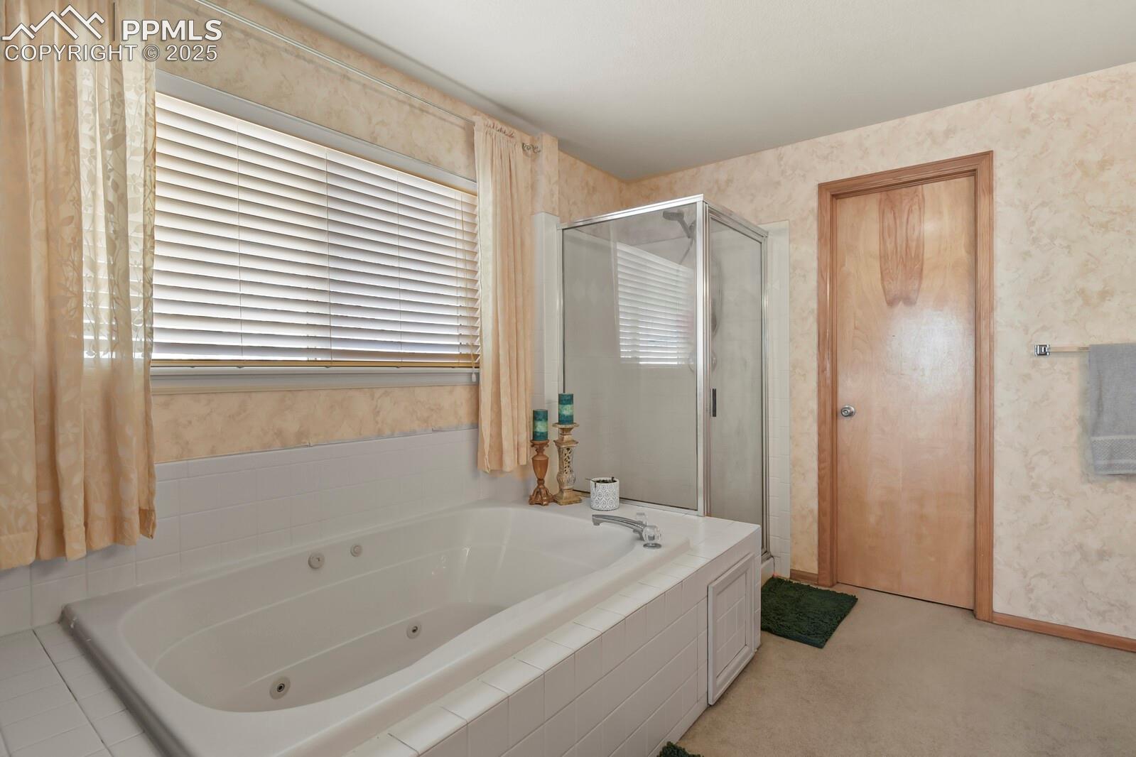 7660 Bullet Road Peyton, CO 80831 - Photo 24 of 50 Full bathroom featuring wallpapered walls, a tub with jets, a stall shower, and light carpet