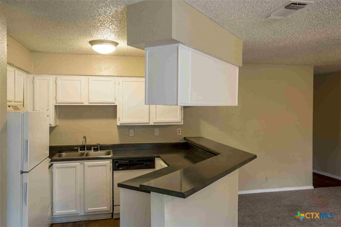 2405 South 13th Street, Unit 721 Temple, TX 76504 - Photo 7 of 9 a kitchen with granite countertop a sink a stove and cabinets
