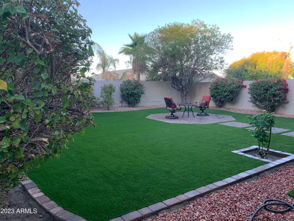 a view of a garden with a bench and trees