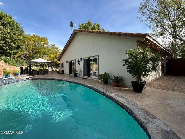 a view of a house with backyard and sitting area
