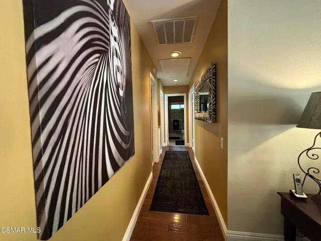 a view of a hallway with wooden floor and door