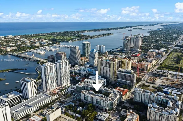 a front view of a multi story residential apartment building with yard and entryway