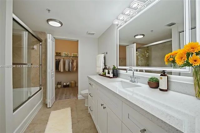 a bathroom with a granite countertop sink a toilet and a bathtub