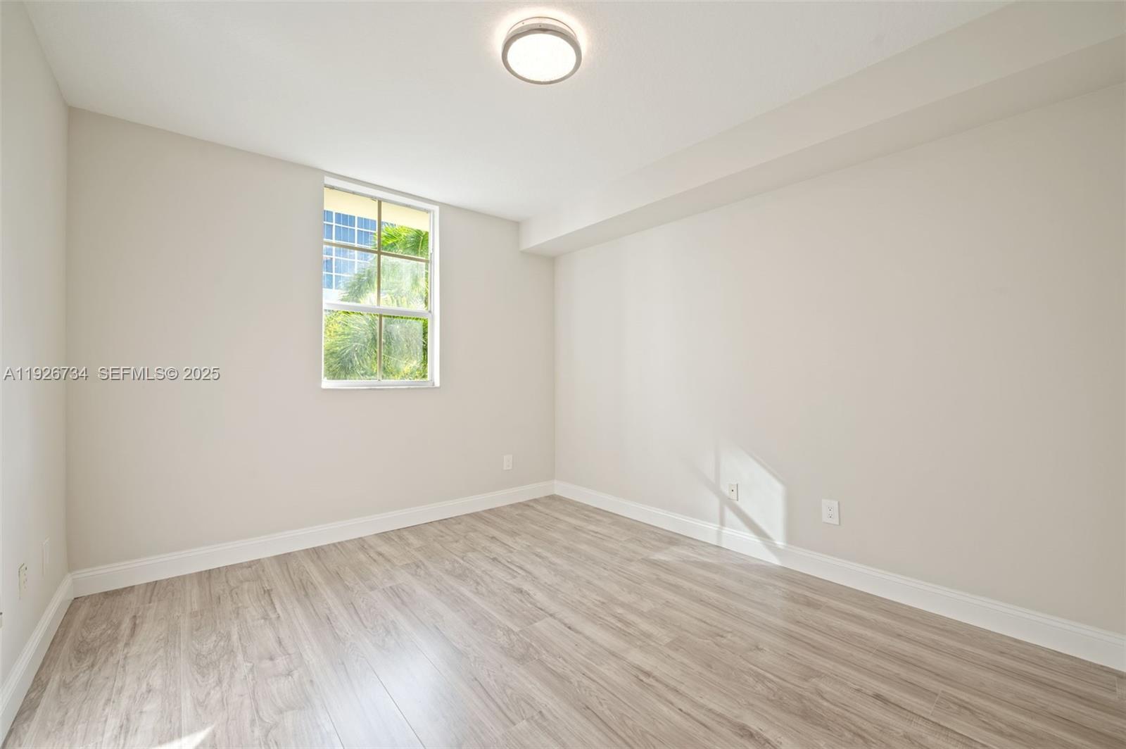 600 South Dixie Highway, Unit 237 West Palm Beach, FL 33401 - Photo 18 of 46 an empty room with wooden floor and windows