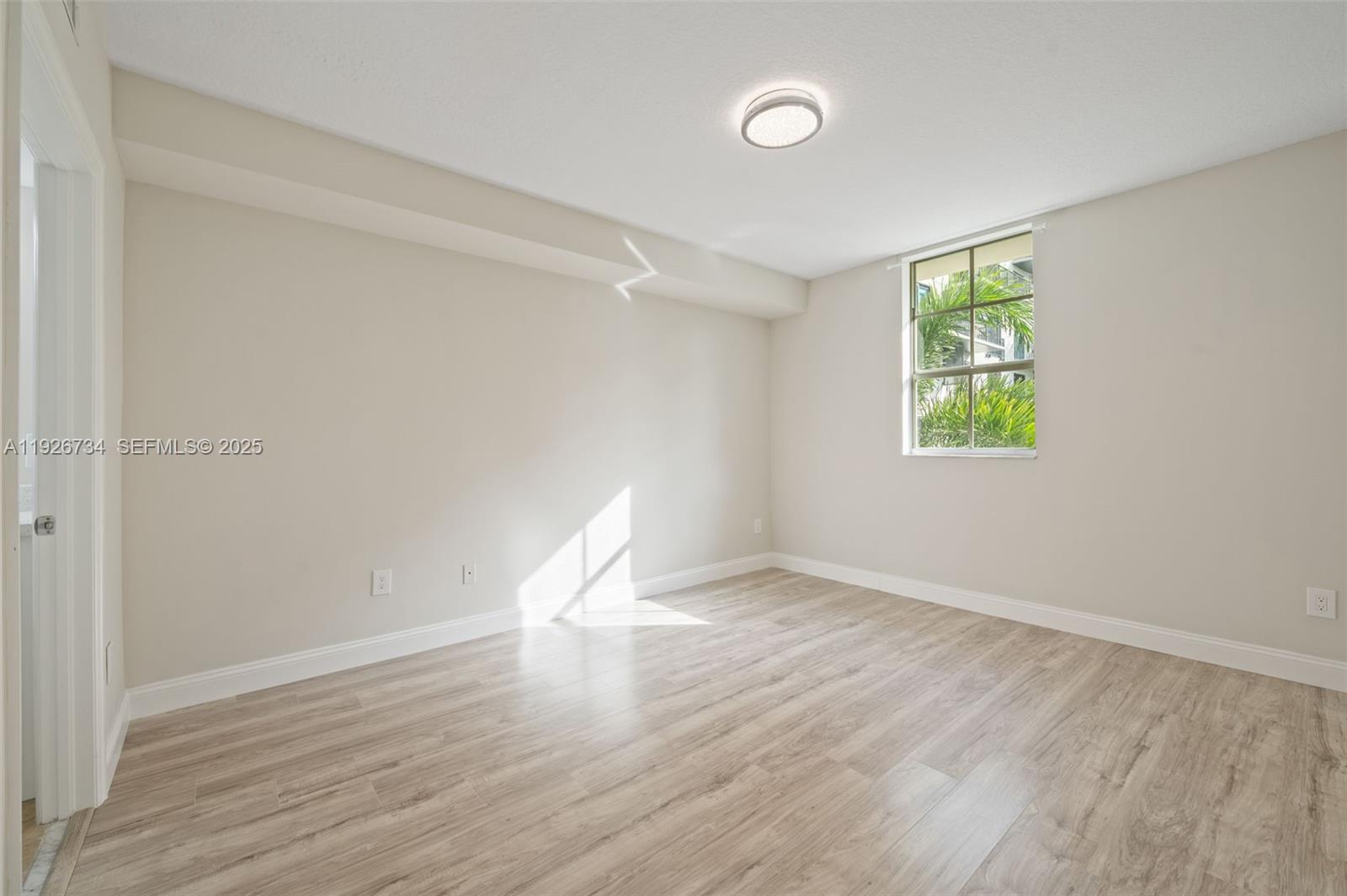 600 South Dixie Highway, Unit 237 West Palm Beach, FL 33401 - Photo 42 of 46 an empty room with wooden floor and windows