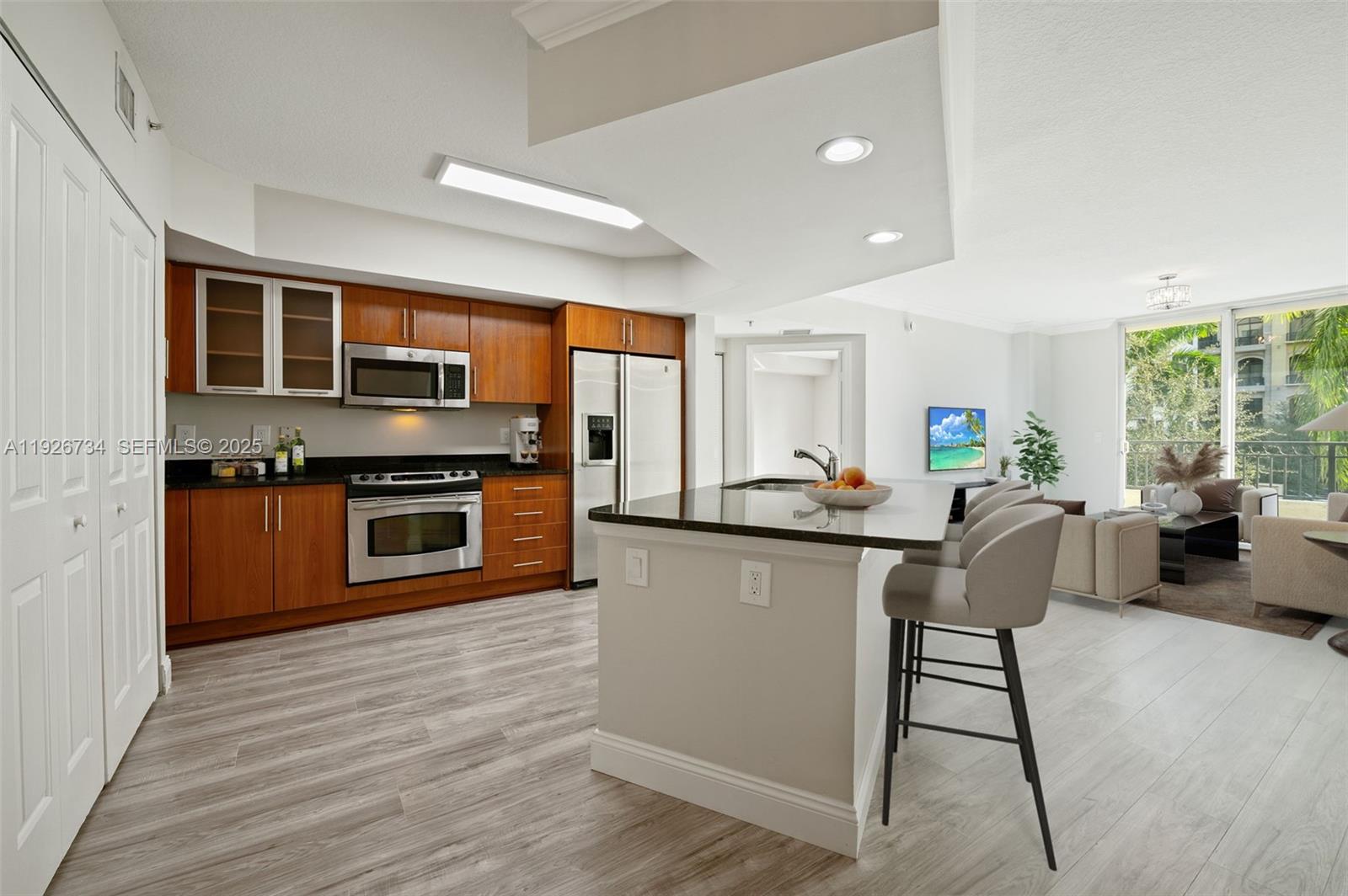 600 South Dixie Highway, Unit 237 West Palm Beach, FL 33401 - Photo 6 of 46 a kitchen with stainless steel appliances granite countertop a stove top oven a sink dishwasher a dining table and chairs with wooden floor