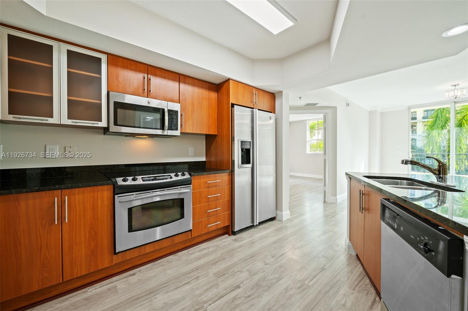 600 South Dixie Highway, Unit 237 West Palm Beach, FL 33401 - Photo 7 of 46 a kitchen with stainless steel appliances granite countertop a stove top oven a sink dishwasher a microwave oven and a refrigerator with wooden floor