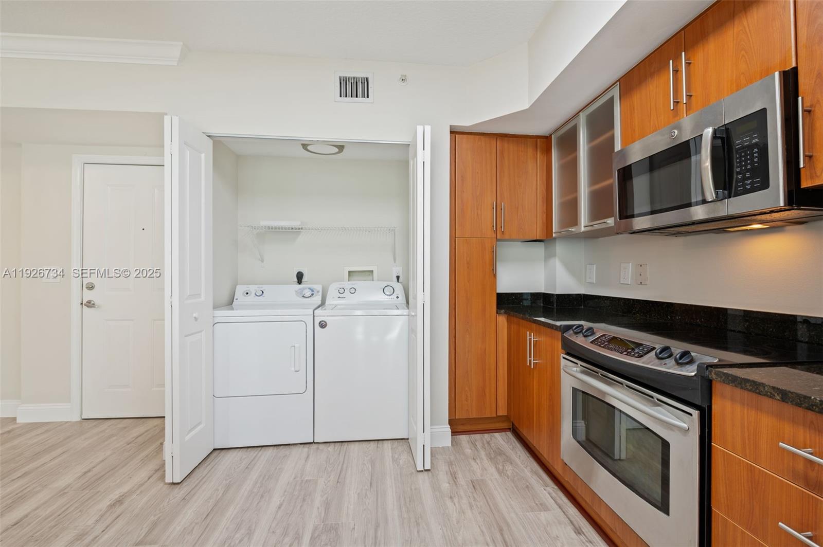 600 South Dixie Highway, Unit 237 West Palm Beach, FL 33401 - Photo 8 of 46 a kitchen with cabinets stainless steel appliances and wooden floor