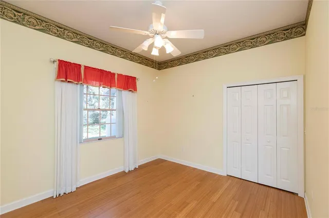 a kitchen with a sink dishwasher a stove and white cabinets with wooden floor