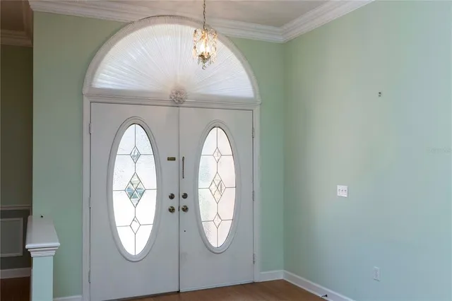 a view of a room with wooden floor chandeliers and kitchen
