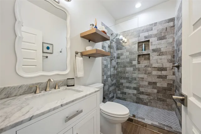 a bathroom with a sink a toilet and shower