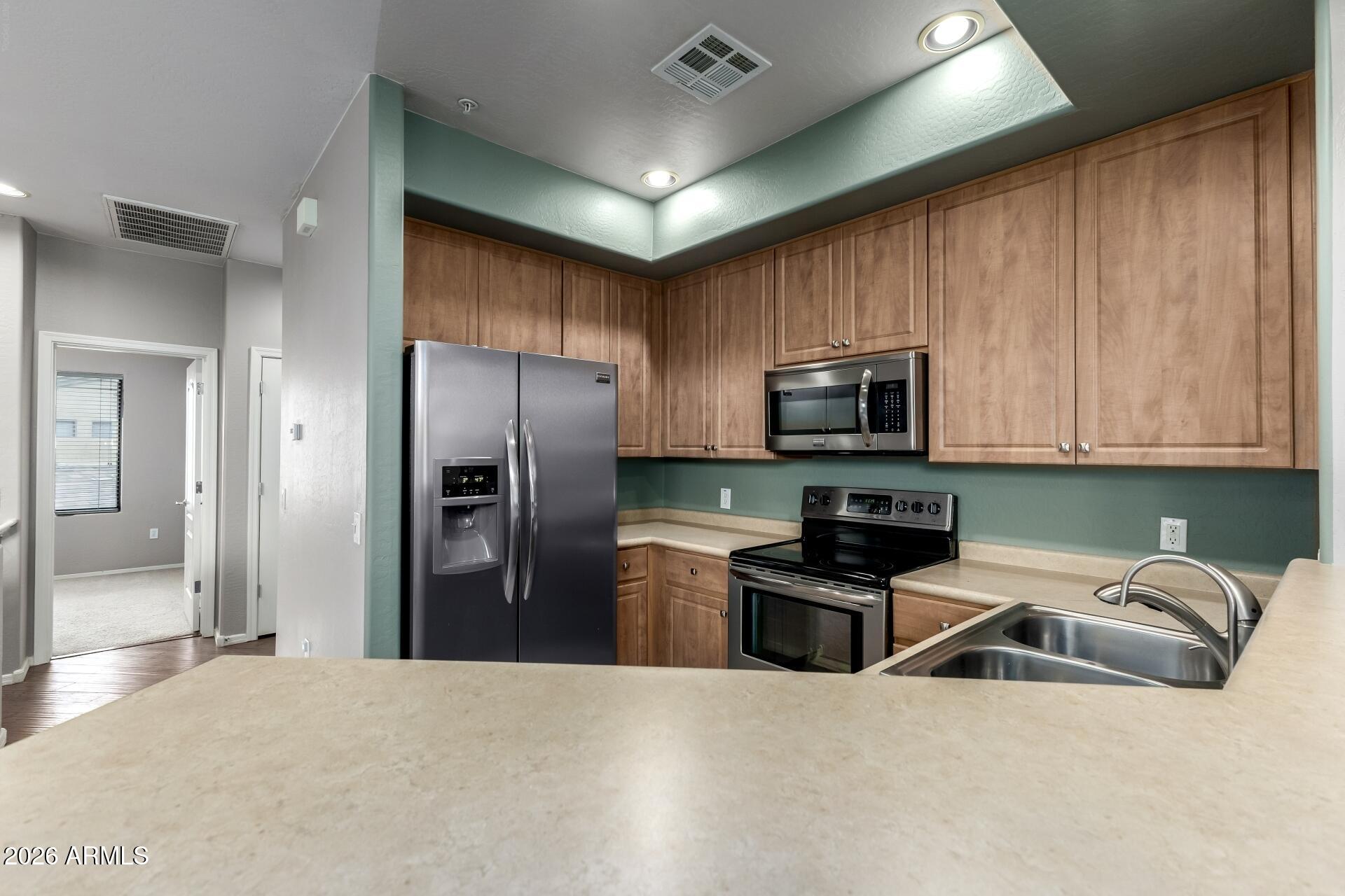 705 West Queen Creek Road, Unit 2114 Chandler, AZ 85248 - Photo 18 of 36 a kitchen with stainless steel appliances granite countertop a refrigerator a stove top oven a sink and dishwasher
