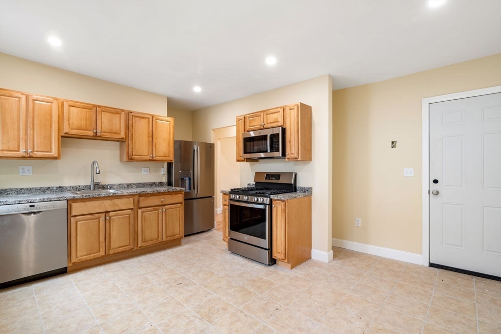 a kitchen with granite countertop stainless steel appliances and white cabinets