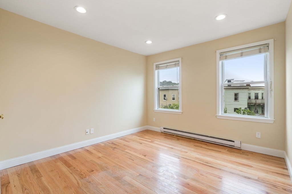 570 Washington Street, Unit 3 Boston, MA 02135 - Photo 4 of 11 an empty room with wooden floor and windows