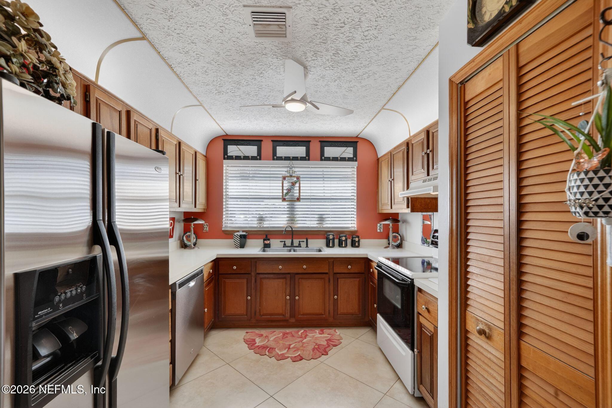 4543 Southeast Dryfus Avenue Stuart, FL 34997 - Photo 14 of 46 a kitchen with stainless steel appliances granite countertop a sink and a refrigerator
