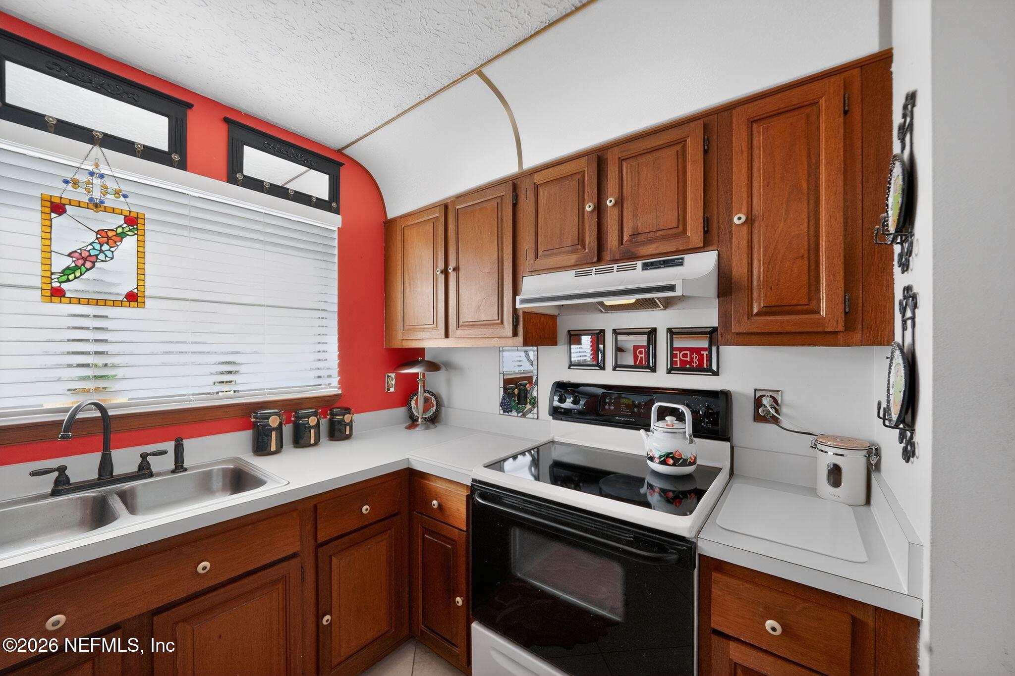 4543 Southeast Dryfus Avenue Stuart, FL 34997 - Photo 16 of 46 a kitchen with stainless steel appliances a stove a sink and cabinets