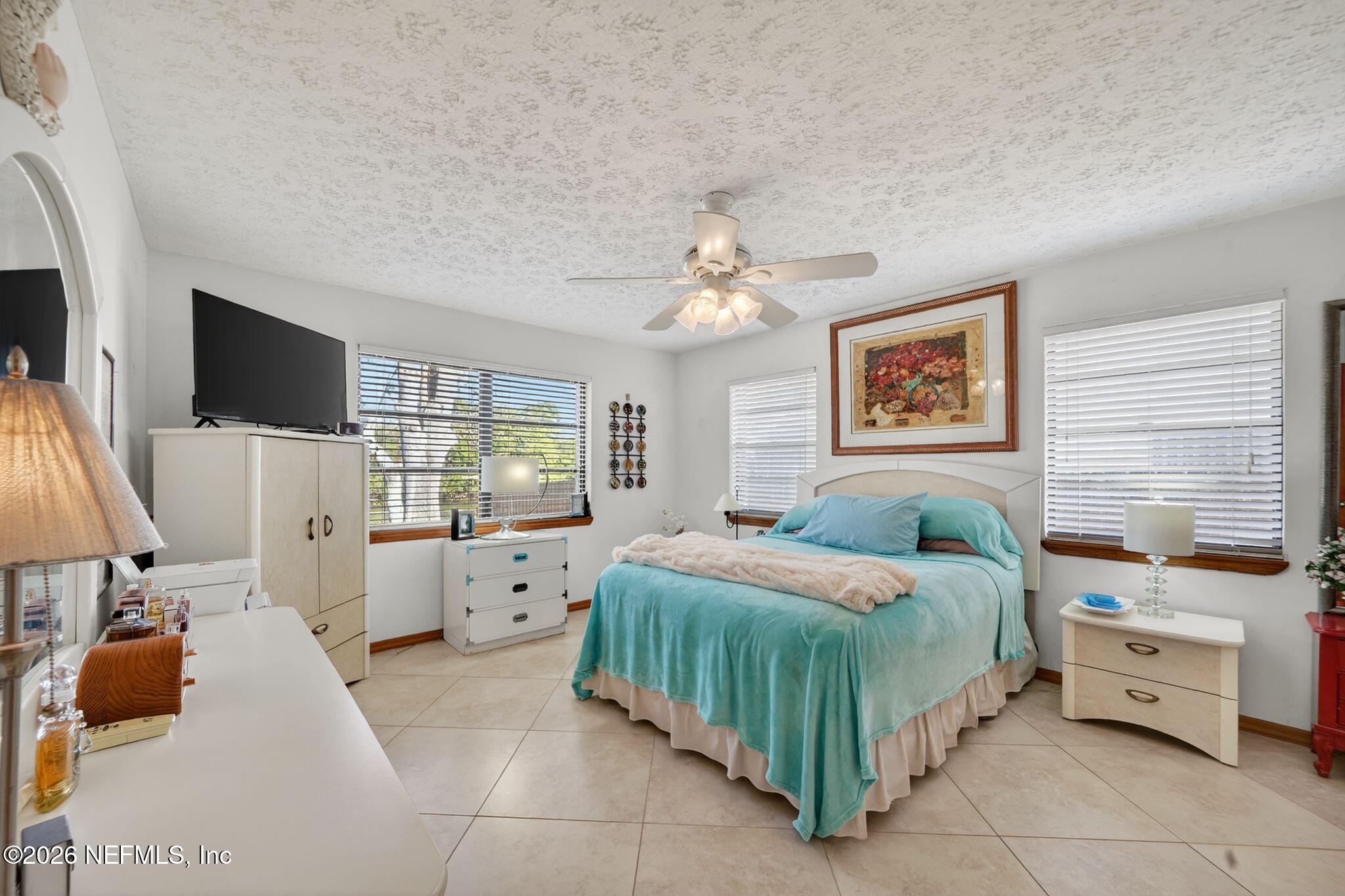 4543 Southeast Dryfus Avenue Stuart, FL 34997 - Photo 17 of 46 a bedroom with a bed and a flat screen tv