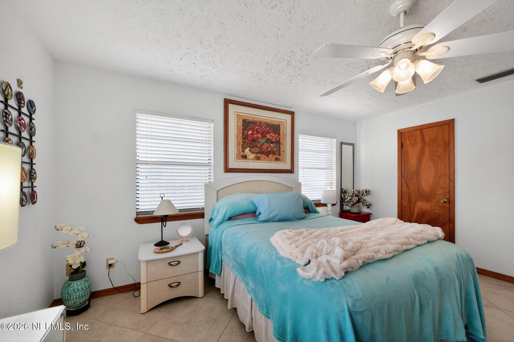 4543 Southeast Dryfus Avenue Stuart, FL 34997 - Photo 18 of 46 a bedroom with two beds and a chandelier