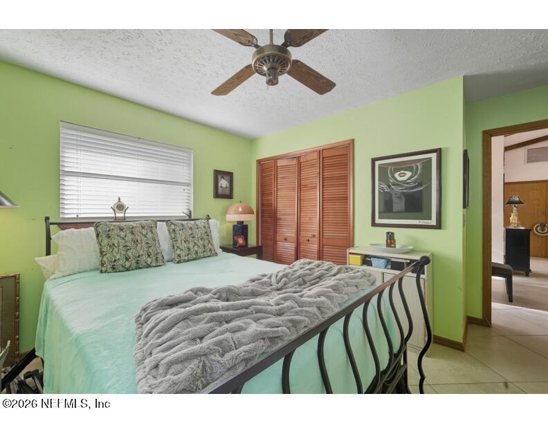 4543 Southeast Dryfus Avenue Stuart, FL 34997 - Photo 23 of 46 a bedroom with a bed a dresser and a chandelier