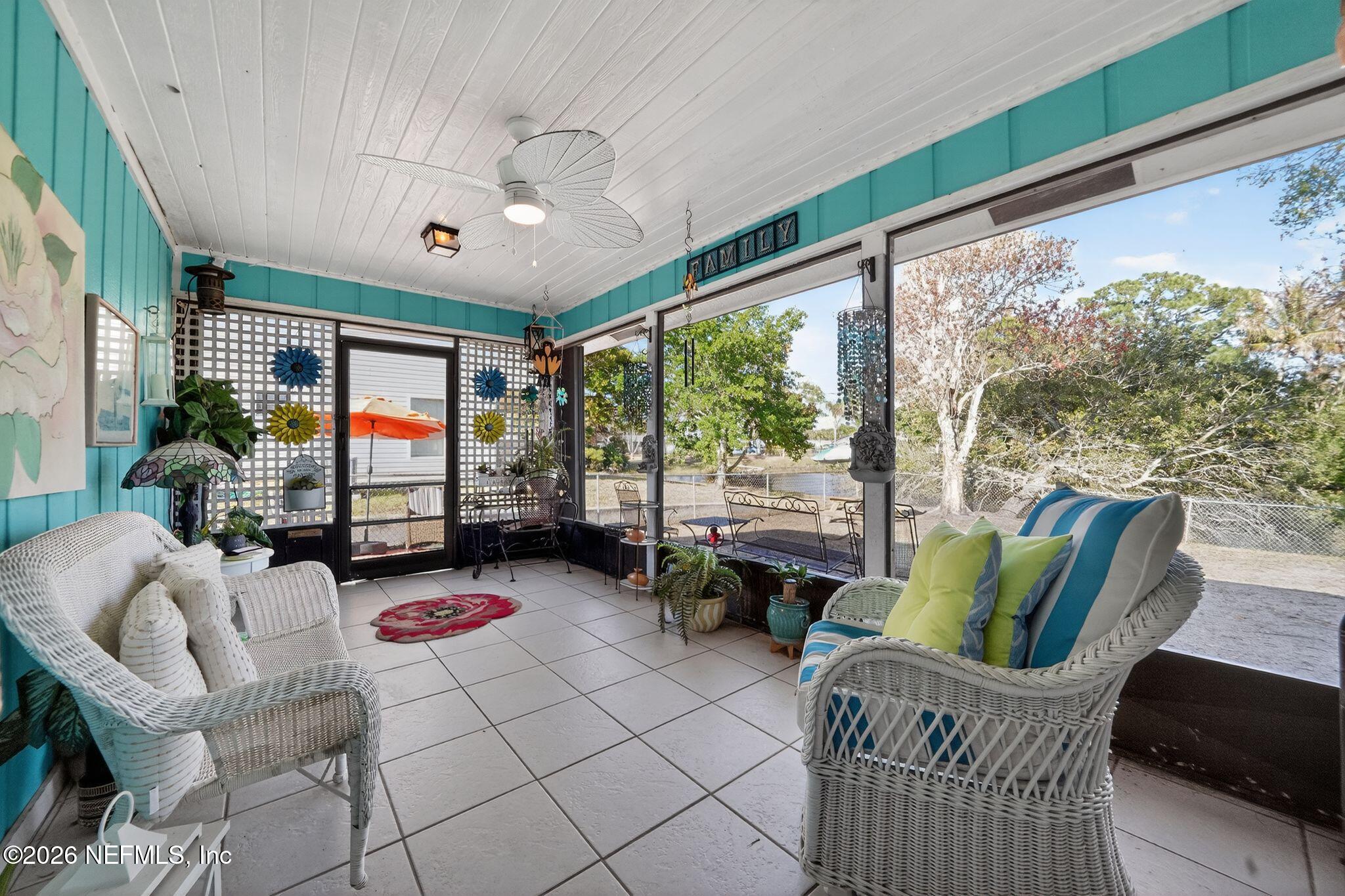4543 Southeast Dryfus Avenue Stuart, FL 34997 - Photo 29 of 46 a living room with furniture and a floor to ceiling window
