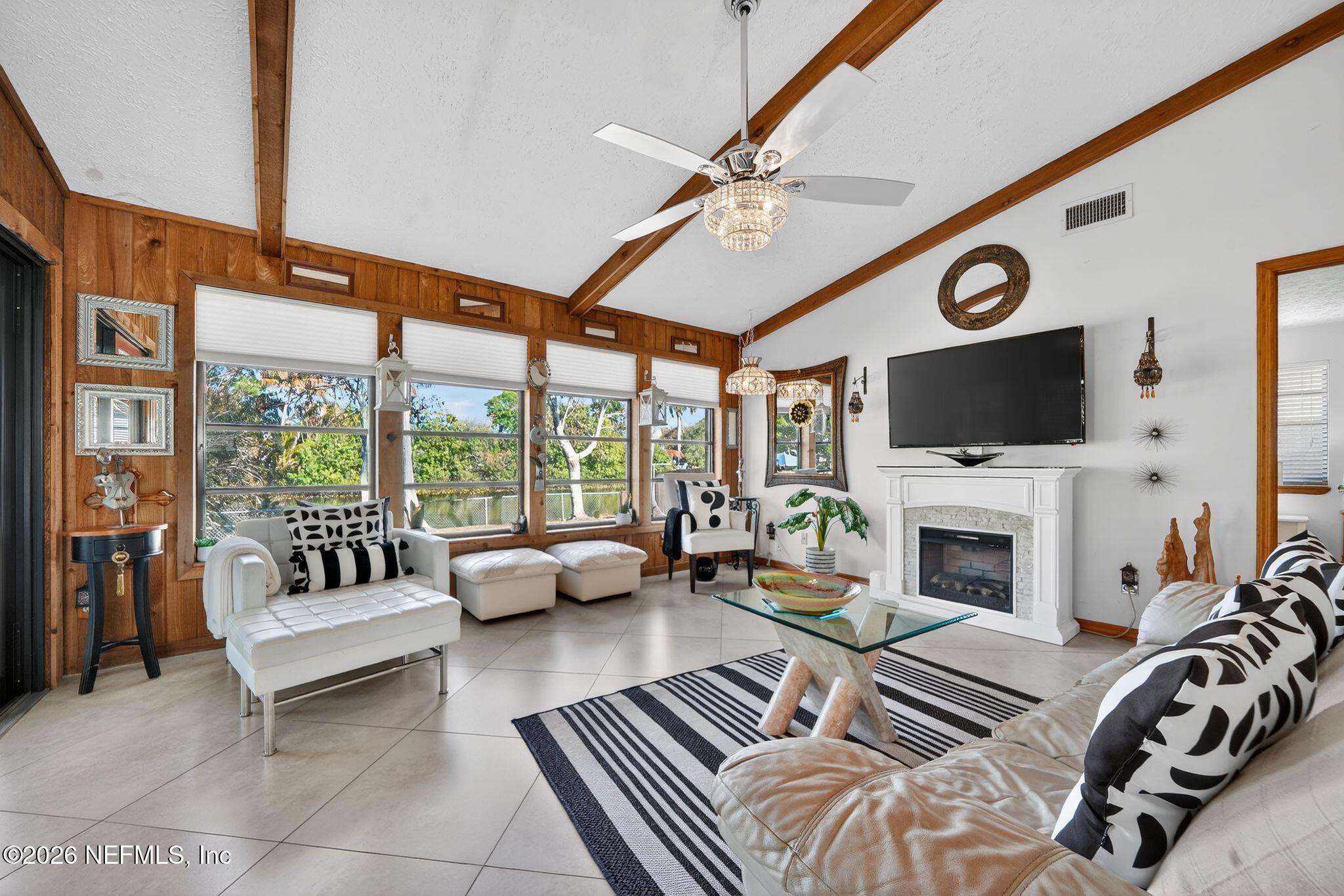 4543 Southeast Dryfus Avenue Stuart, FL 34997 - Photo 8 of 46 a living room with furniture a fireplace and a flat screen tv