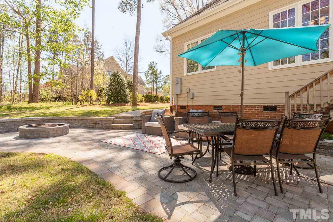 5216 Levering Mill Road Apex, NC 27539 - Photo 13 of 23 a view of patio with chairs and table under an umbrella