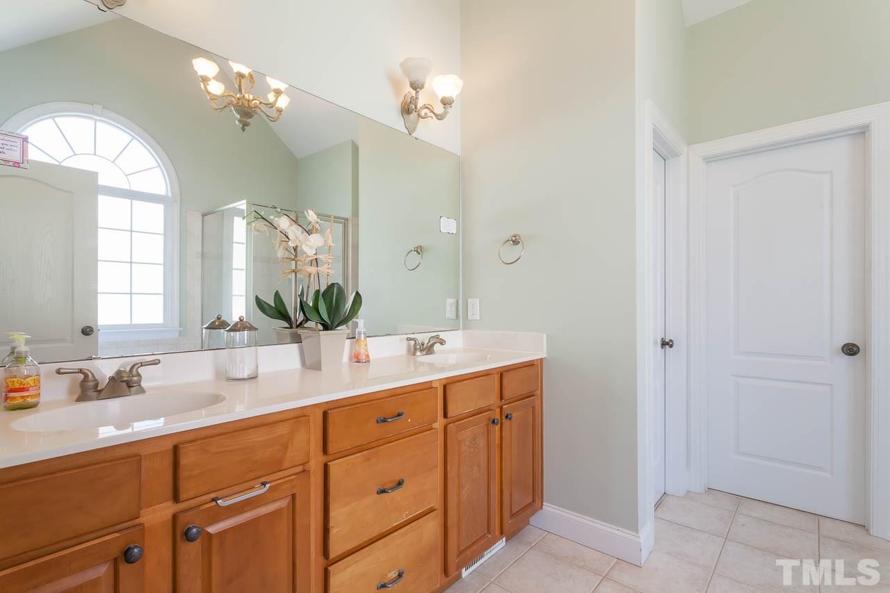 5216 Levering Mill Road Apex, NC 27539 - Photo 15 of 23 a bathroom with a double vanity sink and a mirror