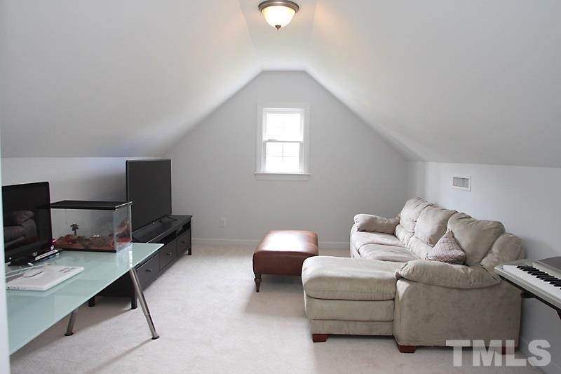 5216 Levering Mill Road Apex, NC 27539 - Photo 22 of 23 a living room with furniture and a flat screen tv