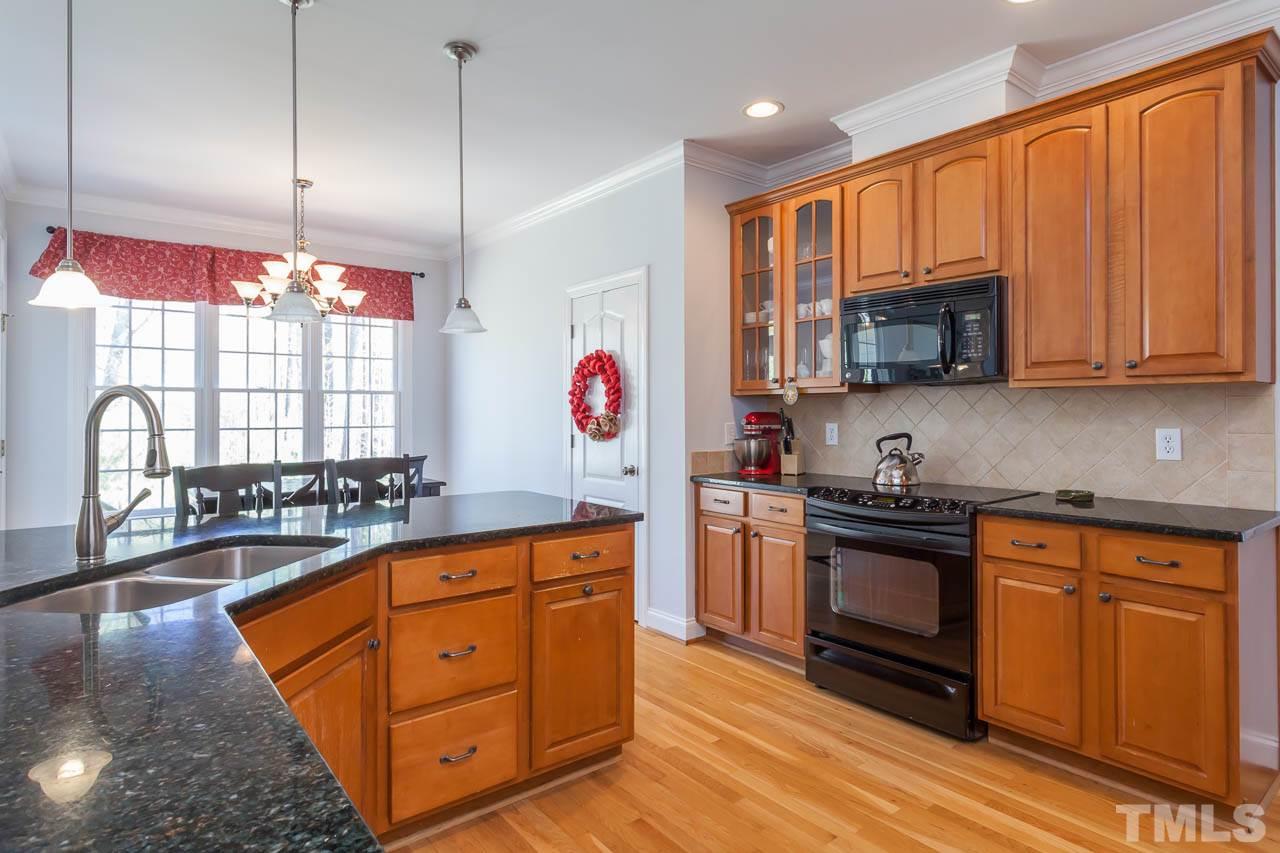 5216 Levering Mill Road Apex, NC 27539 - Photo 7 of 23 a kitchen with stainless steel appliances granite countertop a stove a sink dishwasher and a microwave oven with cabinets