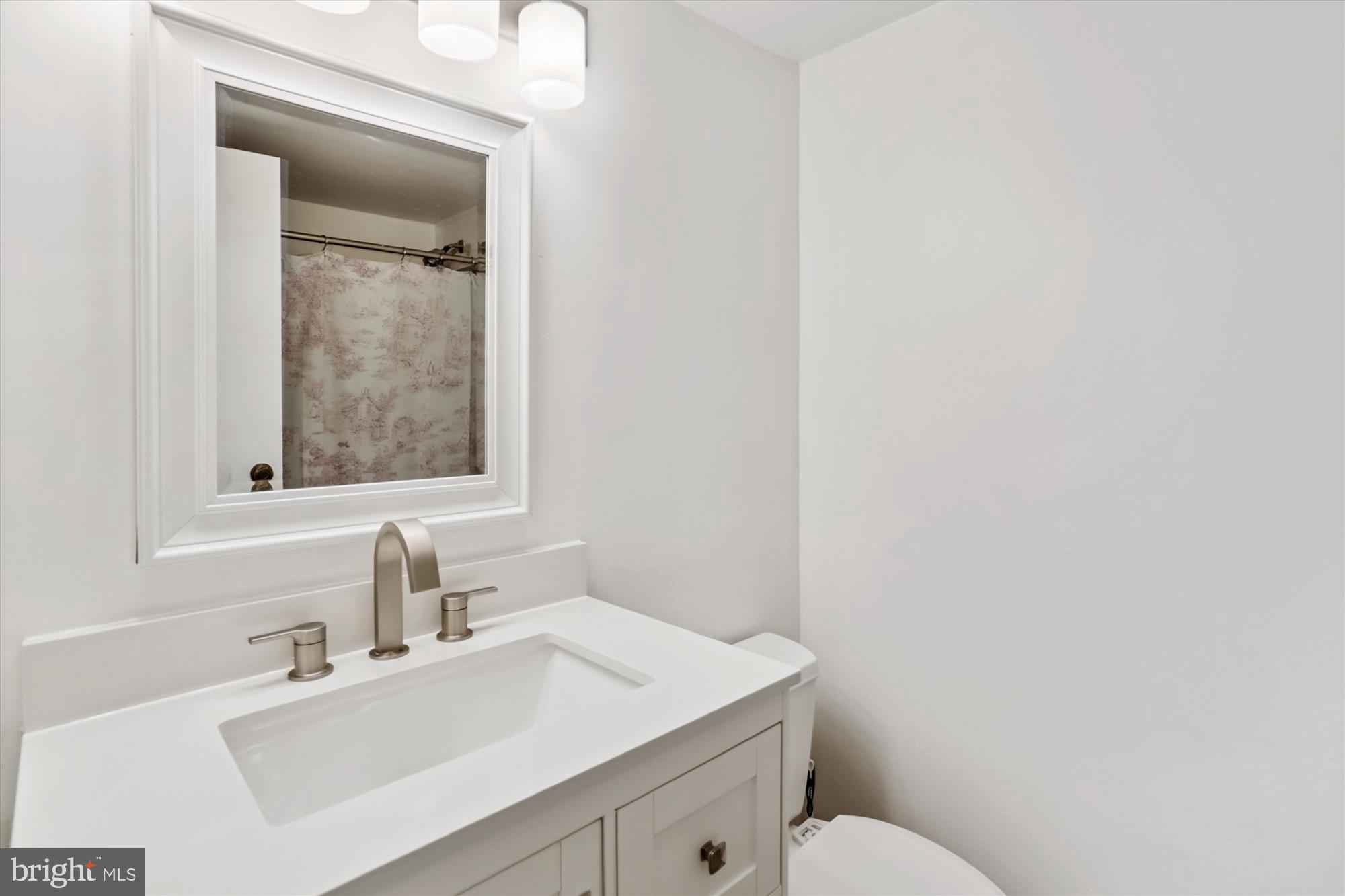 2030 F Street Northwest, Unit 906 Washington, DC 20006 - Photo 26 of 33 a bathroom with a sink vanity mirror and toilet