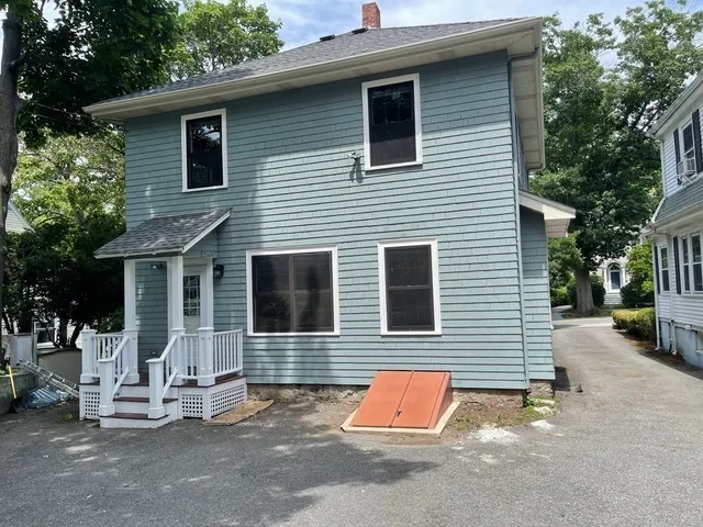 a view of a house with a patio and a yard