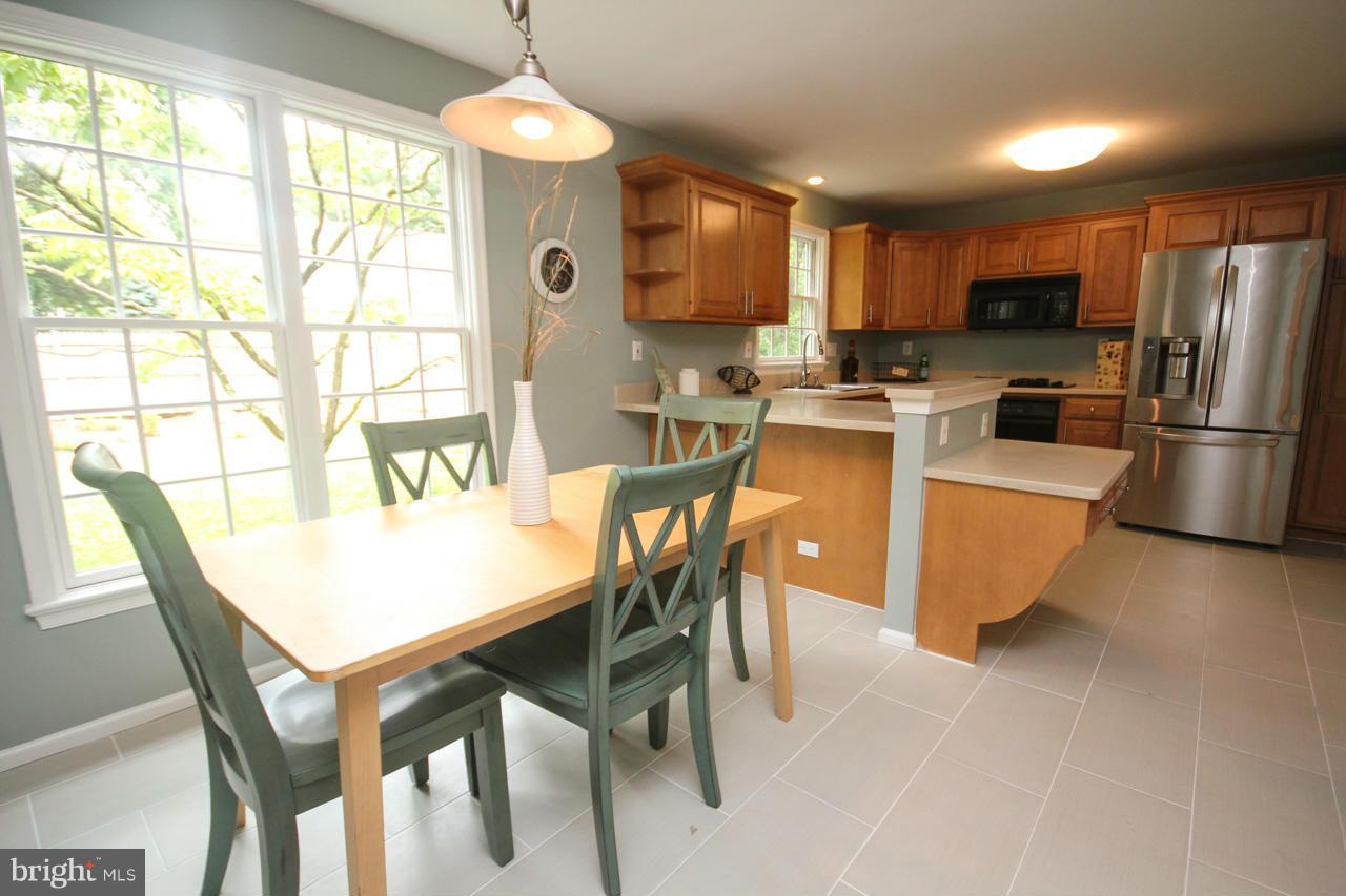 1429 Winding Waye Lane Silver Spring, MD 20902 - Photo 11 of 30 a kitchen with a table chairs refrigerator and microwave