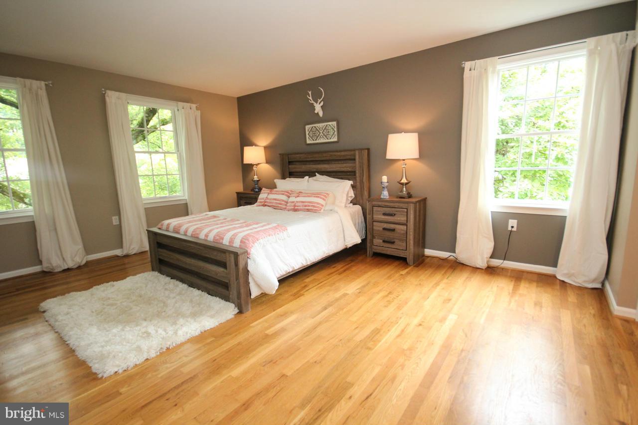 1429 Winding Waye Lane Silver Spring, MD 20902 - Photo 18 of 30 a bedroom with a bed and wooden floor