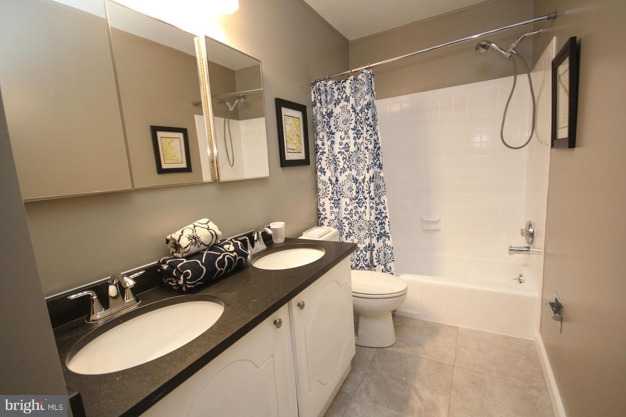 1429 Winding Waye Lane Silver Spring, MD 20902 - Photo 25 of 30 a bathroom with a granite countertop sink toilet and shower