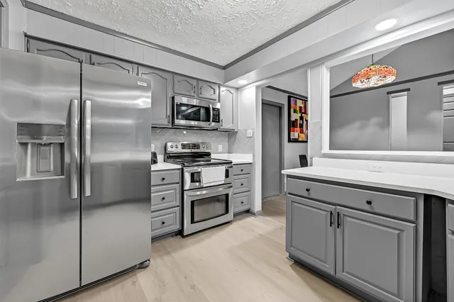 a kitchen with stainless steel appliances cabinets and a refrigerator